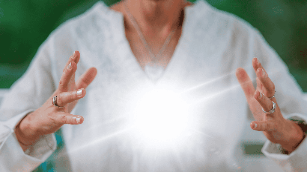 Close-up of a woman's hands capturing a burst of light, symbolizing energy and transformation.