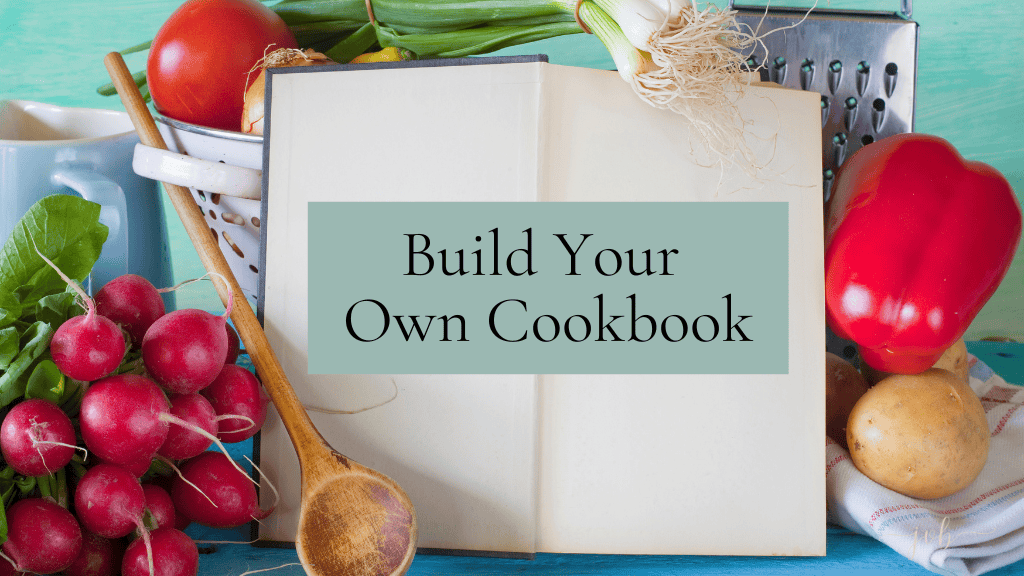 A cookbook titled "Build Your Own Cookbook" surrounded by fresh vegetables, including radishes, tomatoes, green onions, and potatoes, on a blue wooden surface.