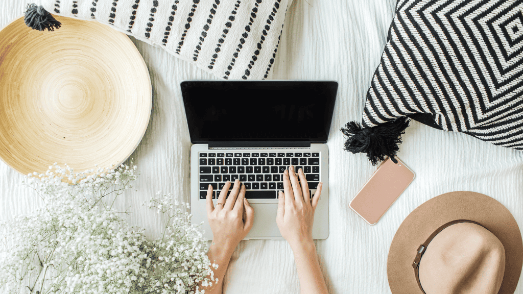 Woman engaging in a self-care lifestyle with laptop and natural decor.