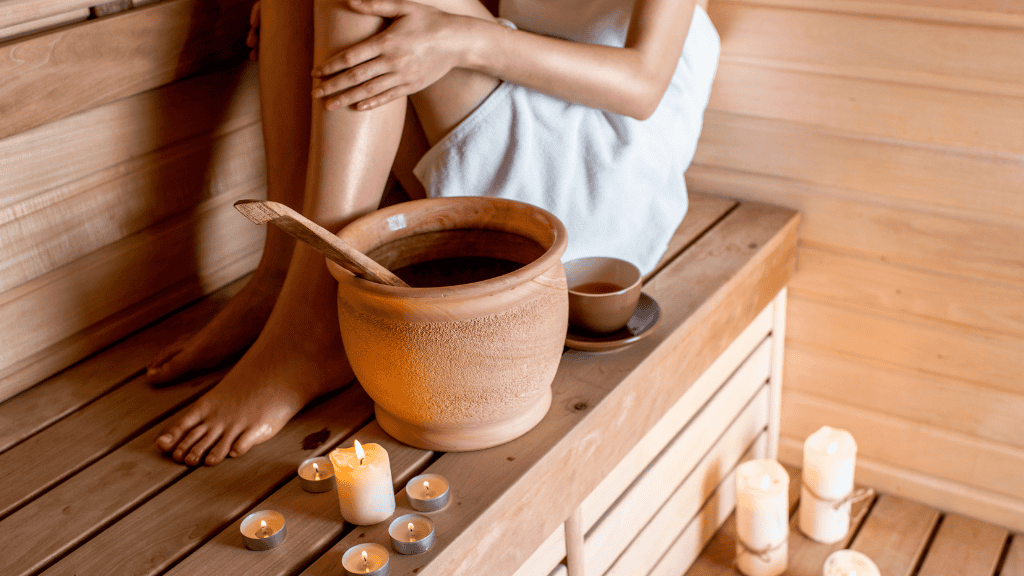 Relaxing sauna session with candles and wooden bucket.