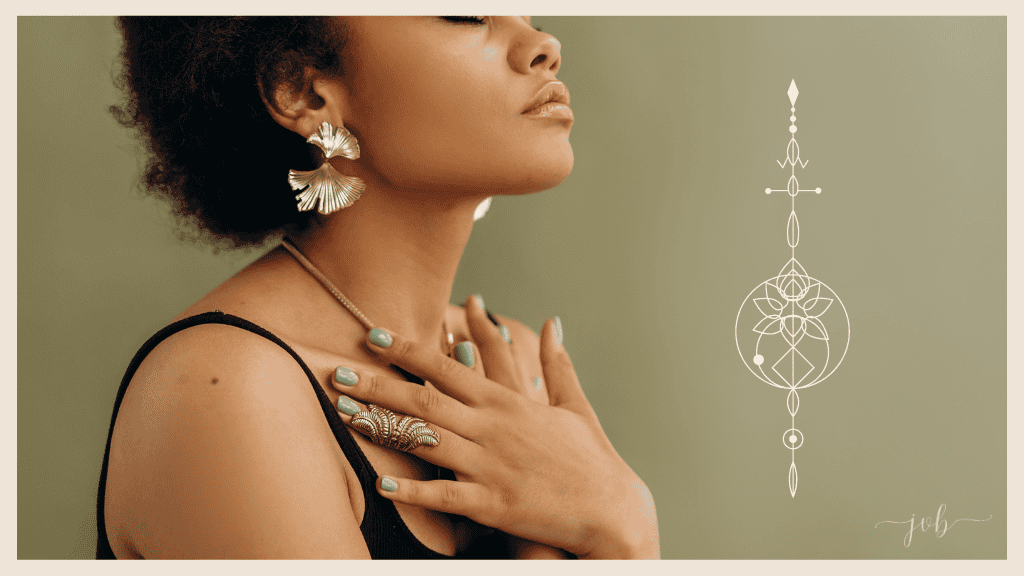 A woman with her head tilted back gracefully, with her hands over her heart, adorned with striking jewelry, exemplifies a moment mindful self-care.